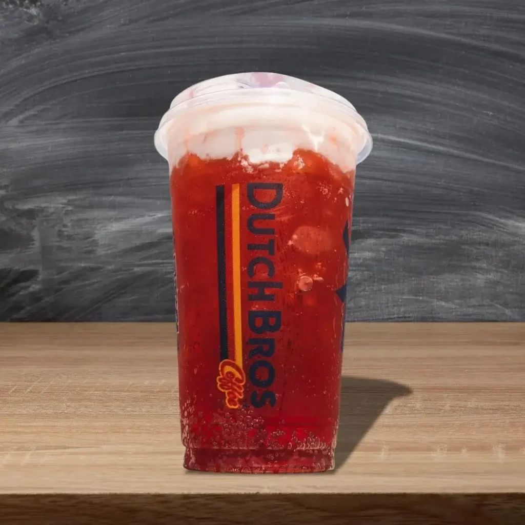 A Rebel Energy Drinks dutch bros placed on a wooden table.