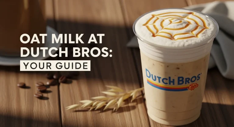 A realistic thumbnail showing a clear Dutch Bros cup with a creamy oat milk latte, froth, and caramel drizzle on a wooden table. Scattered coffee beans and an oat stalk are in the background. Bold text reads "Oat Milk at Dutch Bros: Your Guide" with a subtle 3D shadow effect.